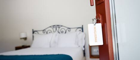 Ein Hotelzimmer mit einem Bett, einem Nachttisch und einer Wandleuchte.