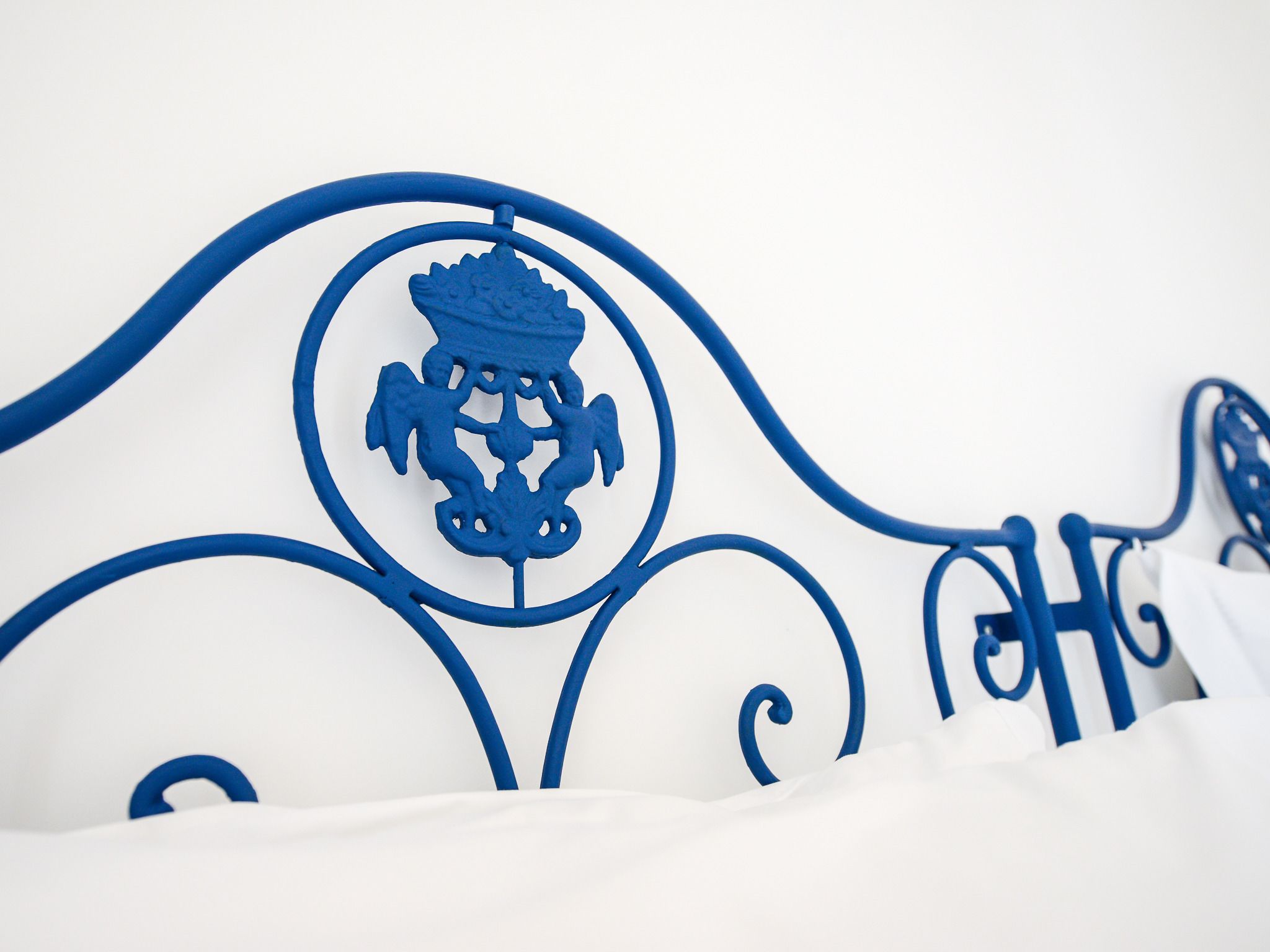 A metal bed frame with a crest emblem.