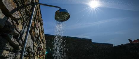 A stone wall with a metal structure and a clear blue sky.
