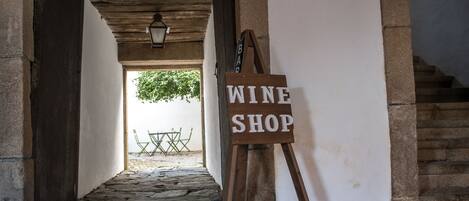 A stone-paved corridor leading to a wine shop sign.