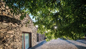 A stone building with a wooden deck and a glass door. - Morgadio da Calçada (Sabrosa)