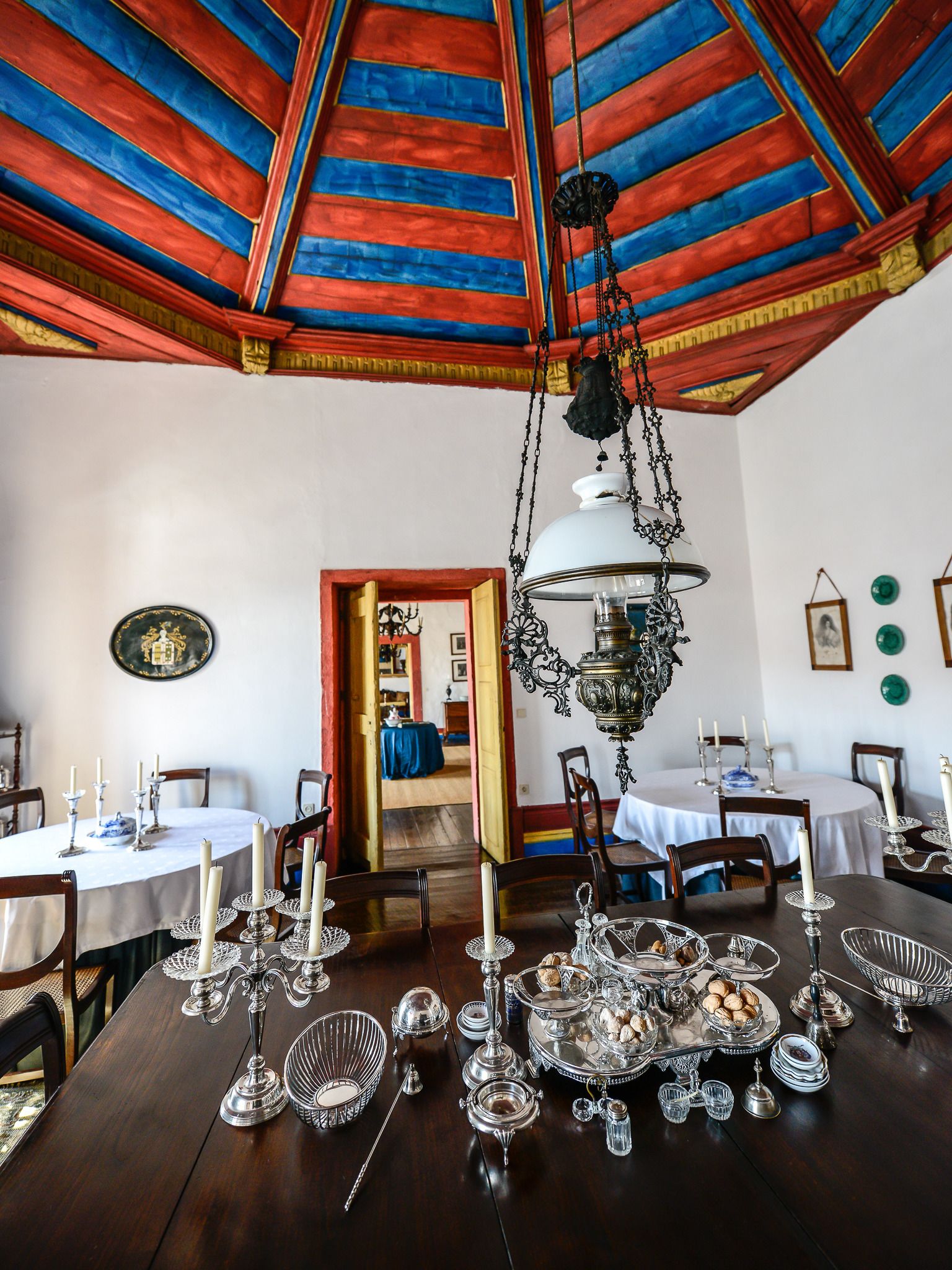 A dining room with a wooden table set for a meal, surrounded by chairs.