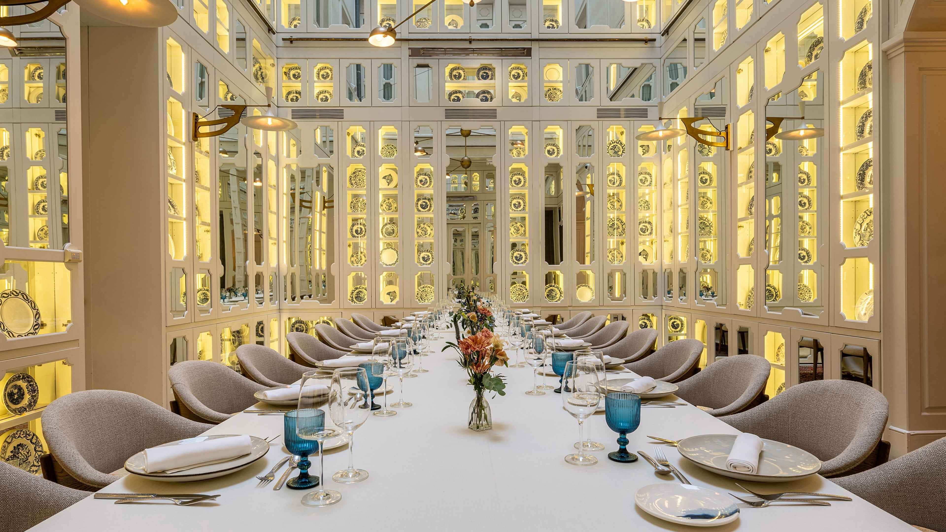 Un comedor formal con una larga mesa, múltiples sillas y un arreglo floral en el centro.