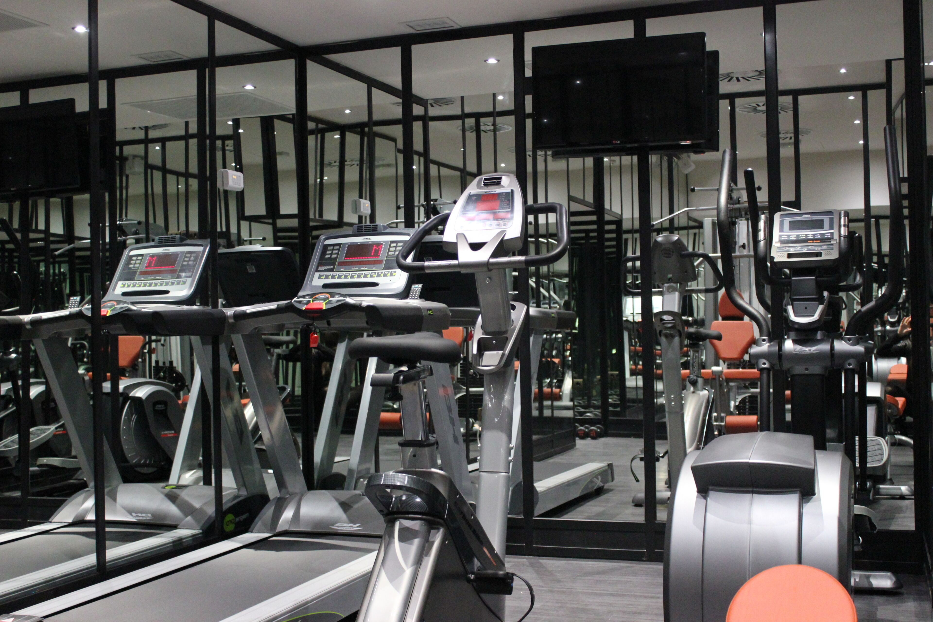 A gym with treadmills, stationary bikes, and weight machines.