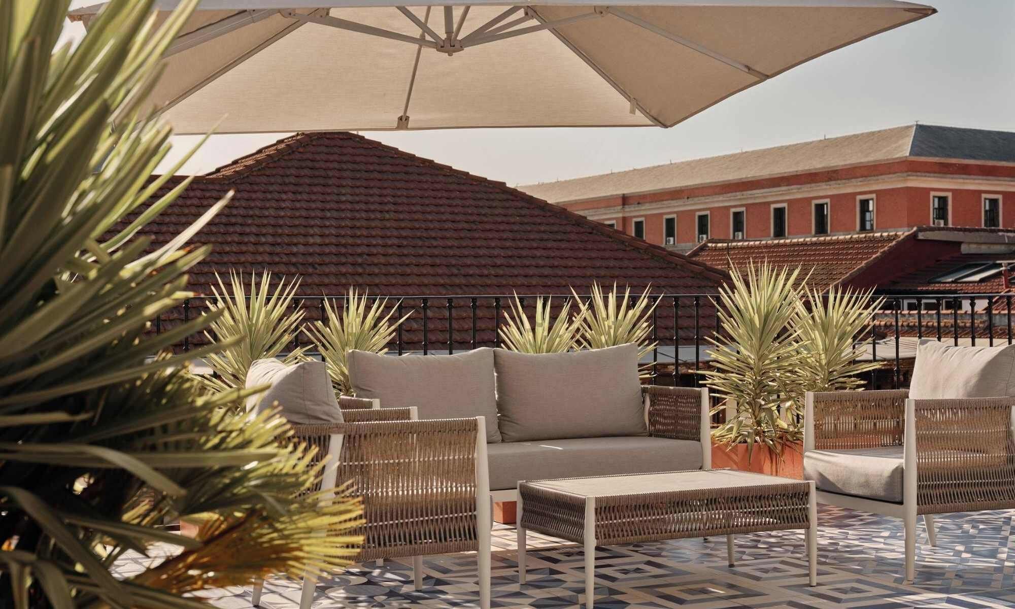 Outdoor seating with umbrellas, wicker furniture, and potted plants.