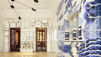 Un vestíbulo con pared de azulejos, una escalera y una puerta que da a una habitación.