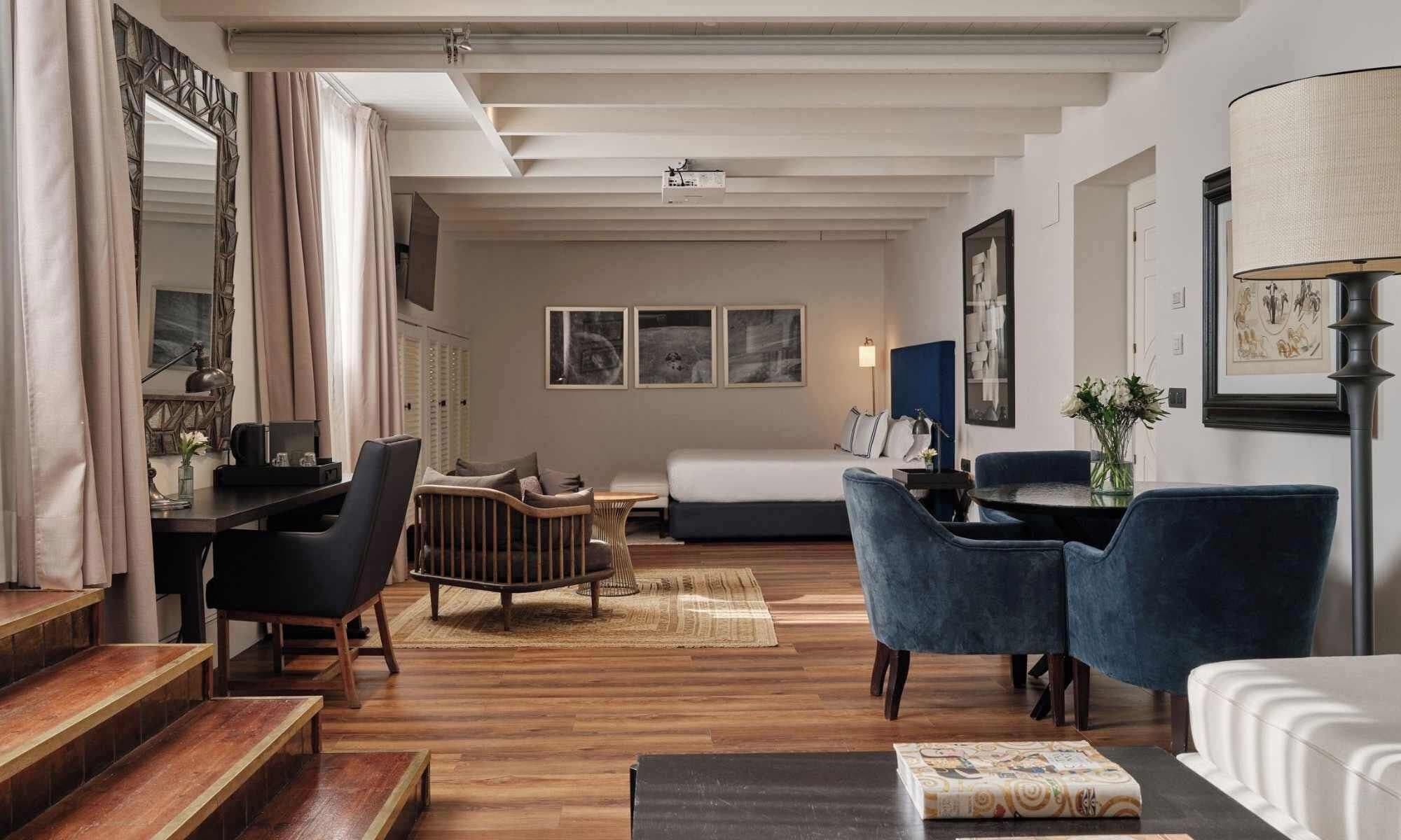 Een moderne woonkamer met een bank, stoelen, een salontafel en een eethoek.