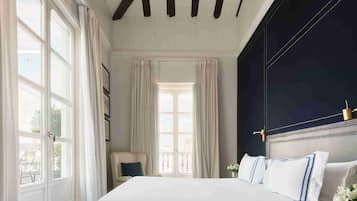 Un dormitorio con una cama grande, una pared de acento oscura y vistas por la ventana.
