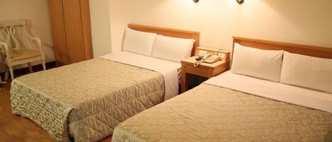 Two single beds with wooden headboards, bedside tables with lamps, and a chair.