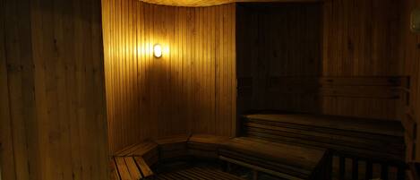 A sauna room with wooden walls and benches.