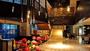 A spacious lobby with a marble floor, a staircase, and a large floral arrangement. - Blue Sky Hotel (Balikpapan)
