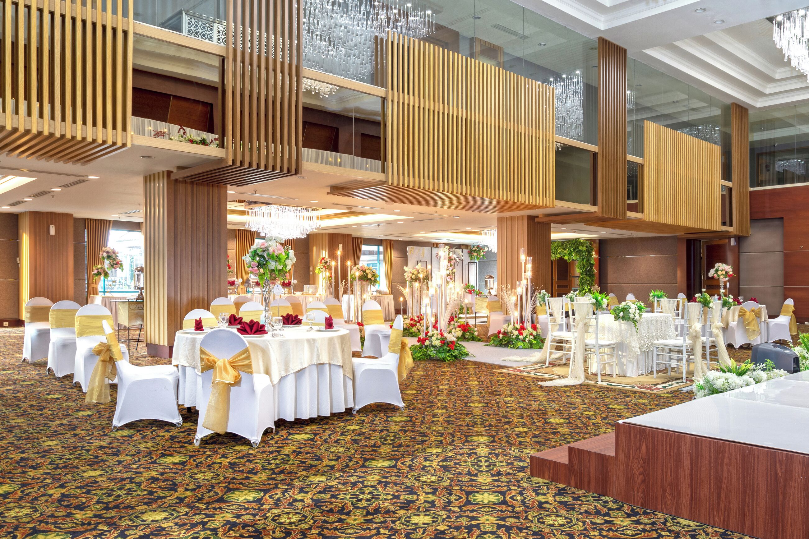 Une salle de banquet avec des tables rondes, des chaises blanches et des décorations florales.