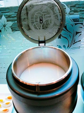 A stainless steel container with a lid, placed on a table with a floral pattern. - OHYA Chain Boutique Motel-Linkou (New Taipei City)