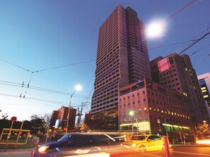 A multi-story building with a modern architectural design, featuring a prominent vertical structure and a flat roof.