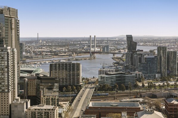 A cityscape with modern high-rise buildings, a river, and a bridge.