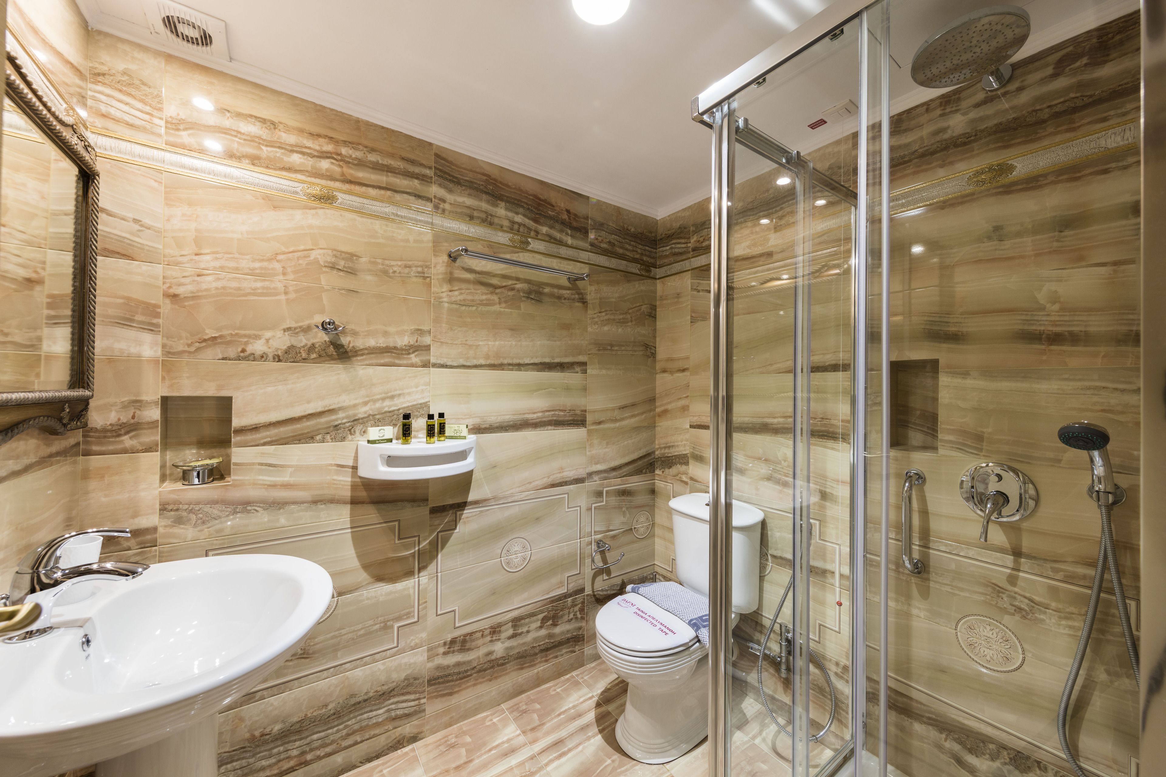A modern bathroom with a glass-enclosed shower, a sink, and a toilet.