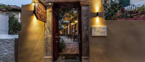 A warmly lit entrance to a building with a sign reading "Pension Dafiti."