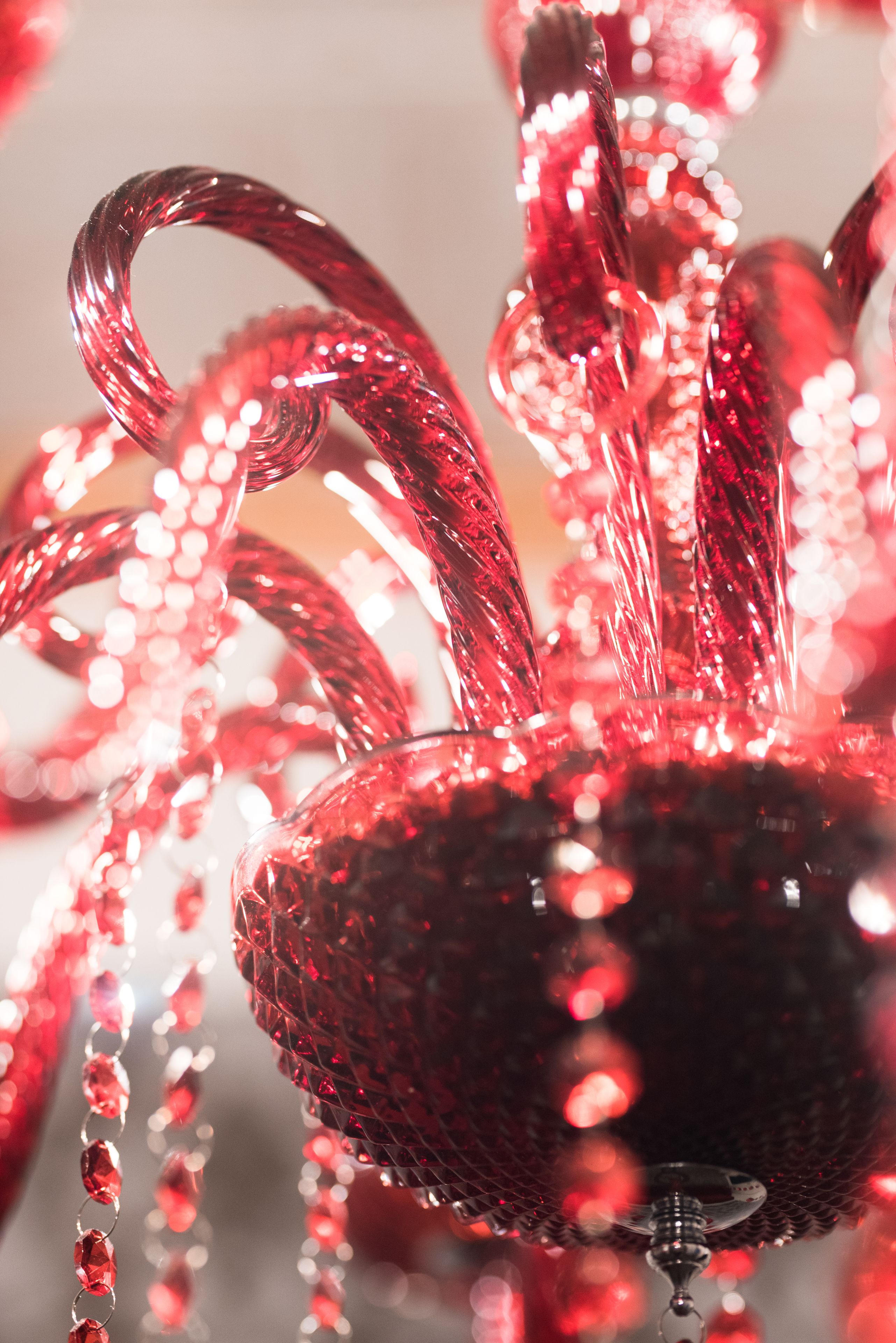 A close-up of a red, glittery Christmas ornament with a shiny, reflective surface.