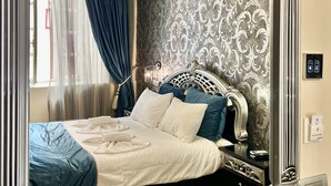 A bedroom with a four-poster bed, ornate wall paneling, and a chandelier. - Pension Dafni (Nafplio)