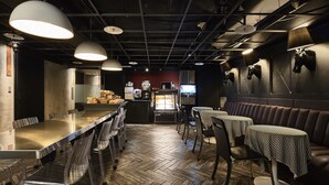 A restaurant interior with a long counter, metal chairs, and tables with checkered tablecloths. - Via Hotel Loft (Taipei)