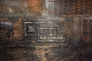 A metal plaque with the text "VIA HOTEL" and "LOFT" on a rusted surface. - Via Hotel Loft (Taipei)