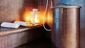 A modern bathroom with a mosaic tile wall, a heated bench, a shower, and a small table with a towel. - Cottonina Hotel & Mineral SPA Resort (Swieradow-Zdroj)