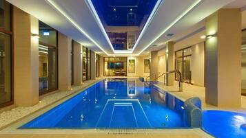 Relax by the pool surrounded by a textured floor and large windows.