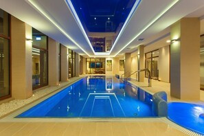 Una piscina techada, sillones reclinables de piscina