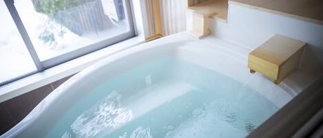 Une baignoire donnant sur une terrasse en bois.