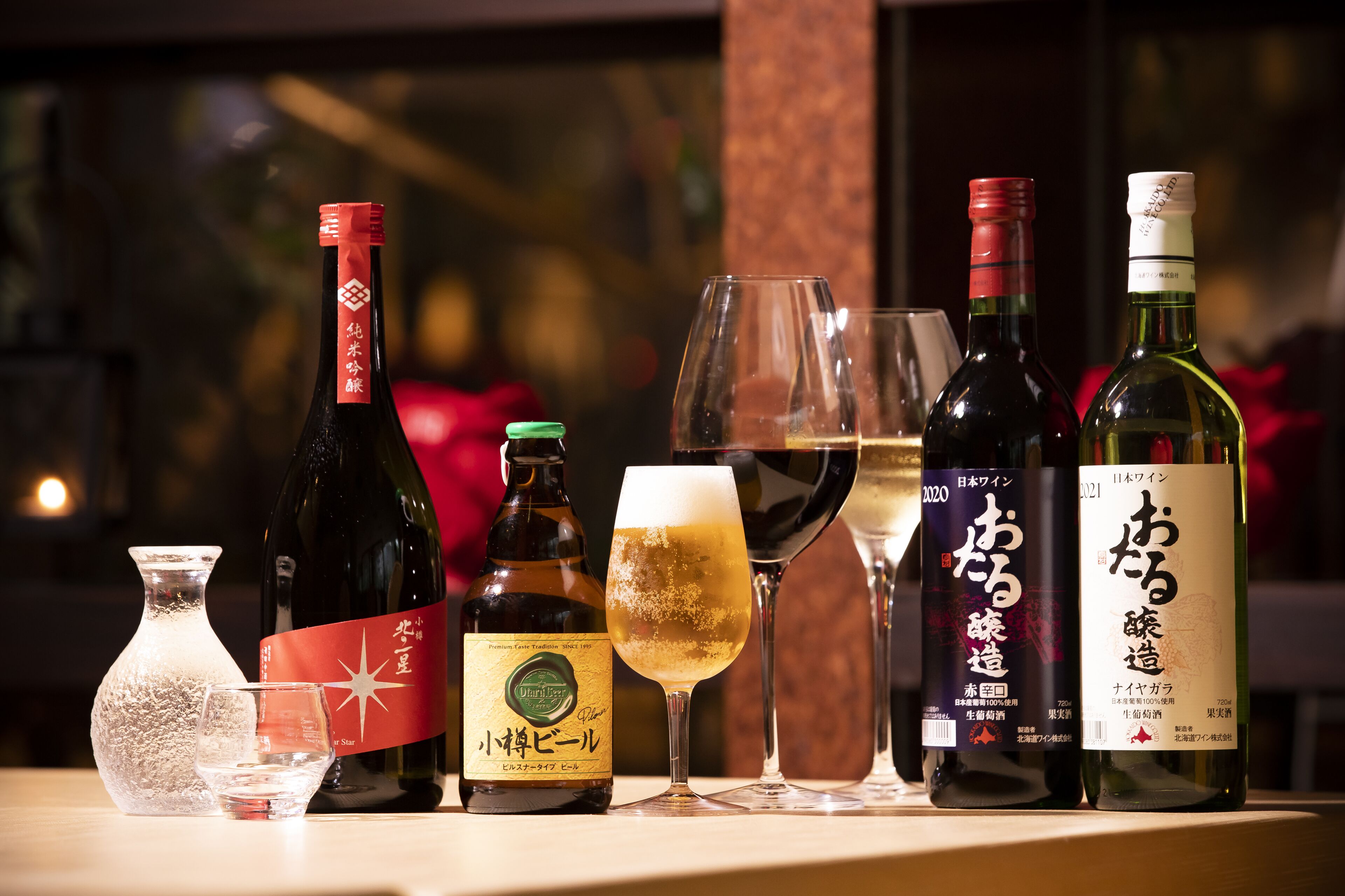 A selection of wine bottles and glasses on a table.