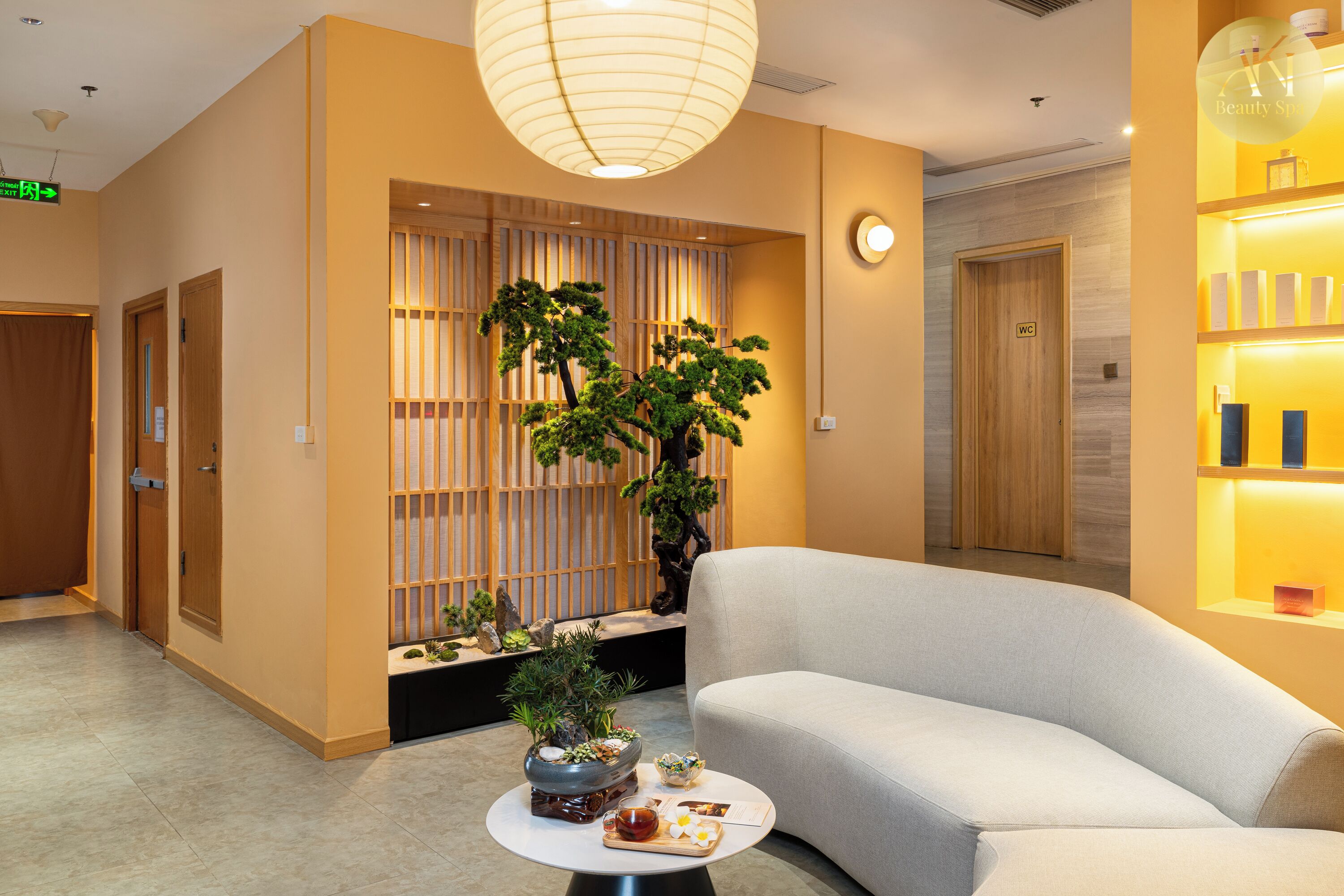 A hotel lobby with a reception desk, a seating area, and a wall-mounted display case.