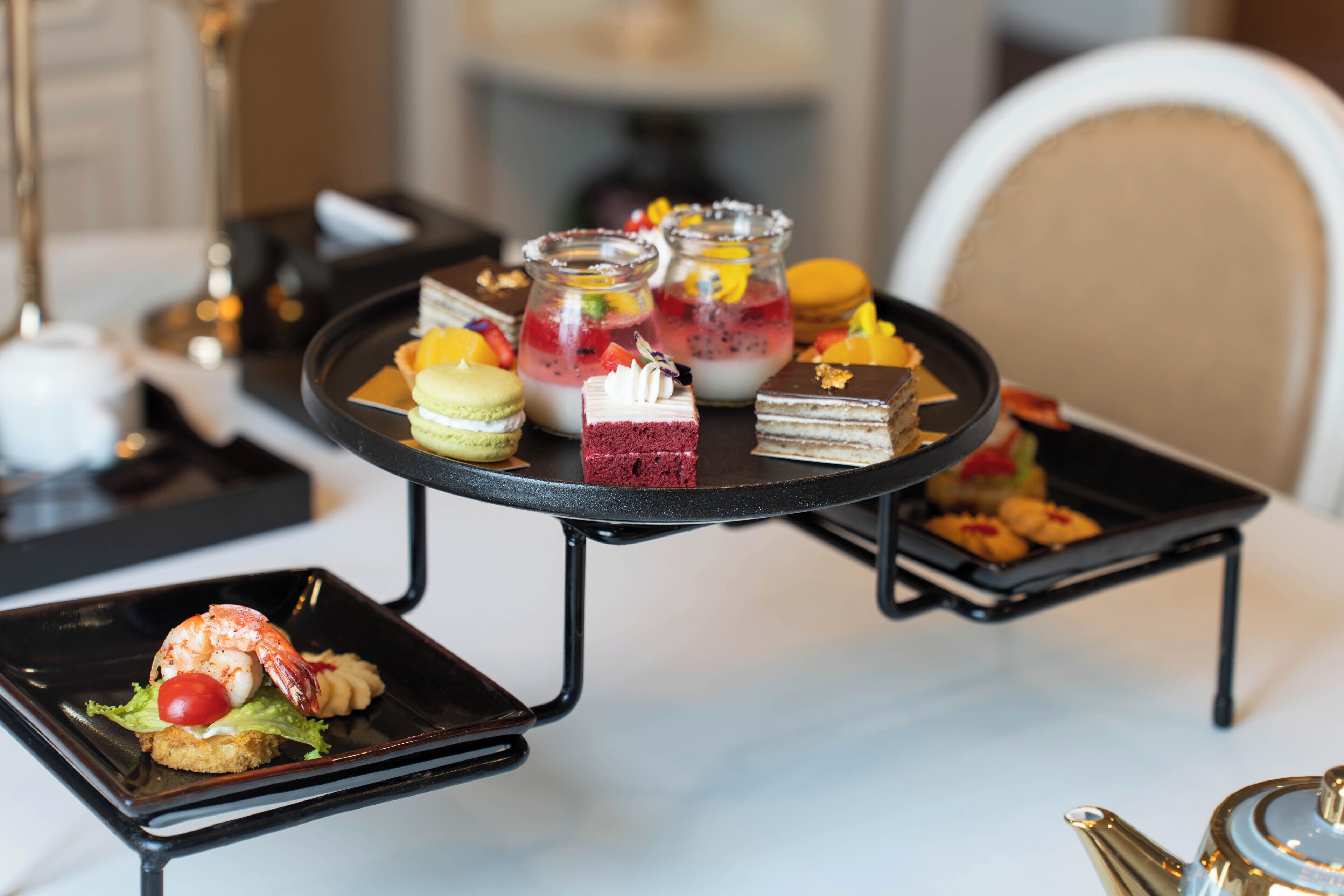 A dessert table with various pastries and a lobster tail.