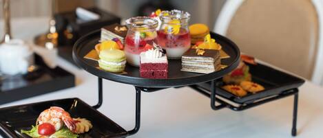 A dessert table with various pastries and a lobster tail.