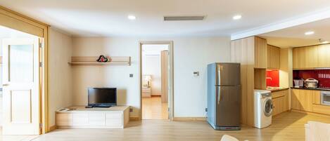 Ein modernes Apartment mit Wohnzimmer, Küche und Waschbereich.