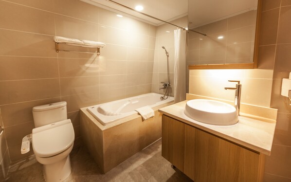A modern bathroom with a toilet, a bathtub, and a sink.