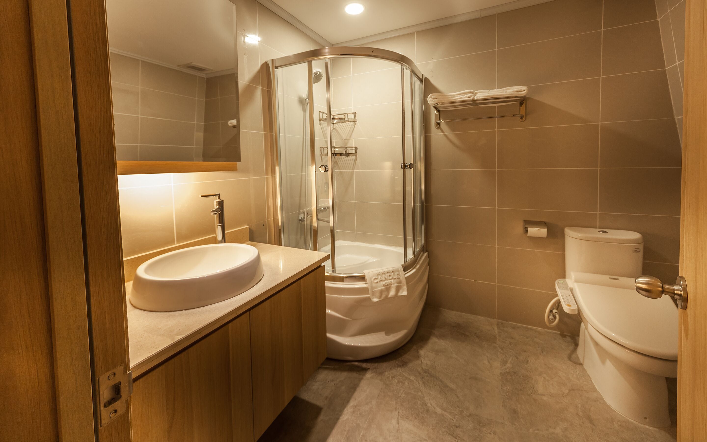 A modern bathroom with a glass-enclosed shower, a sink, and a toilet.