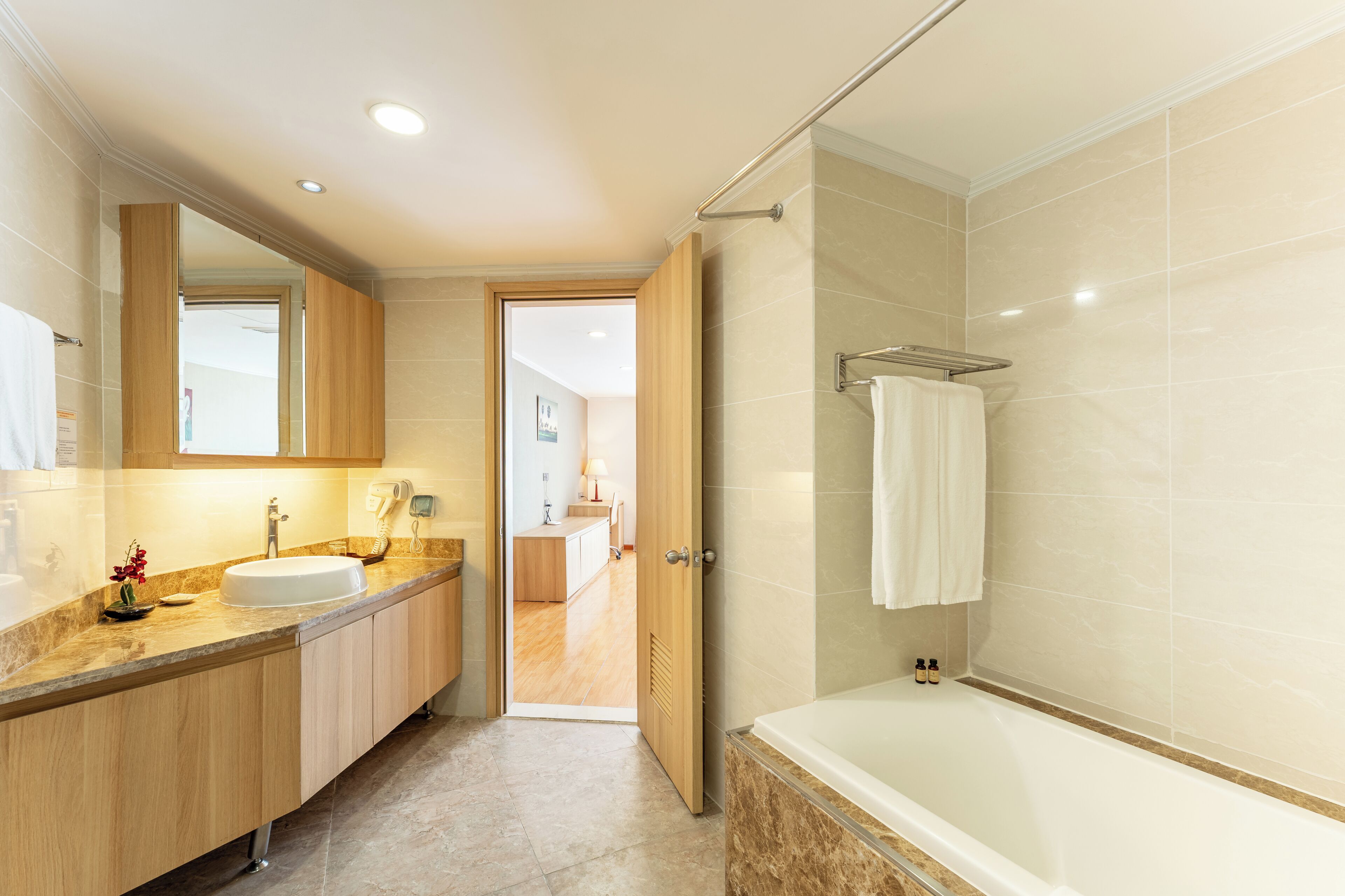 Un baño moderno con lavamanos, espejo y bañera.