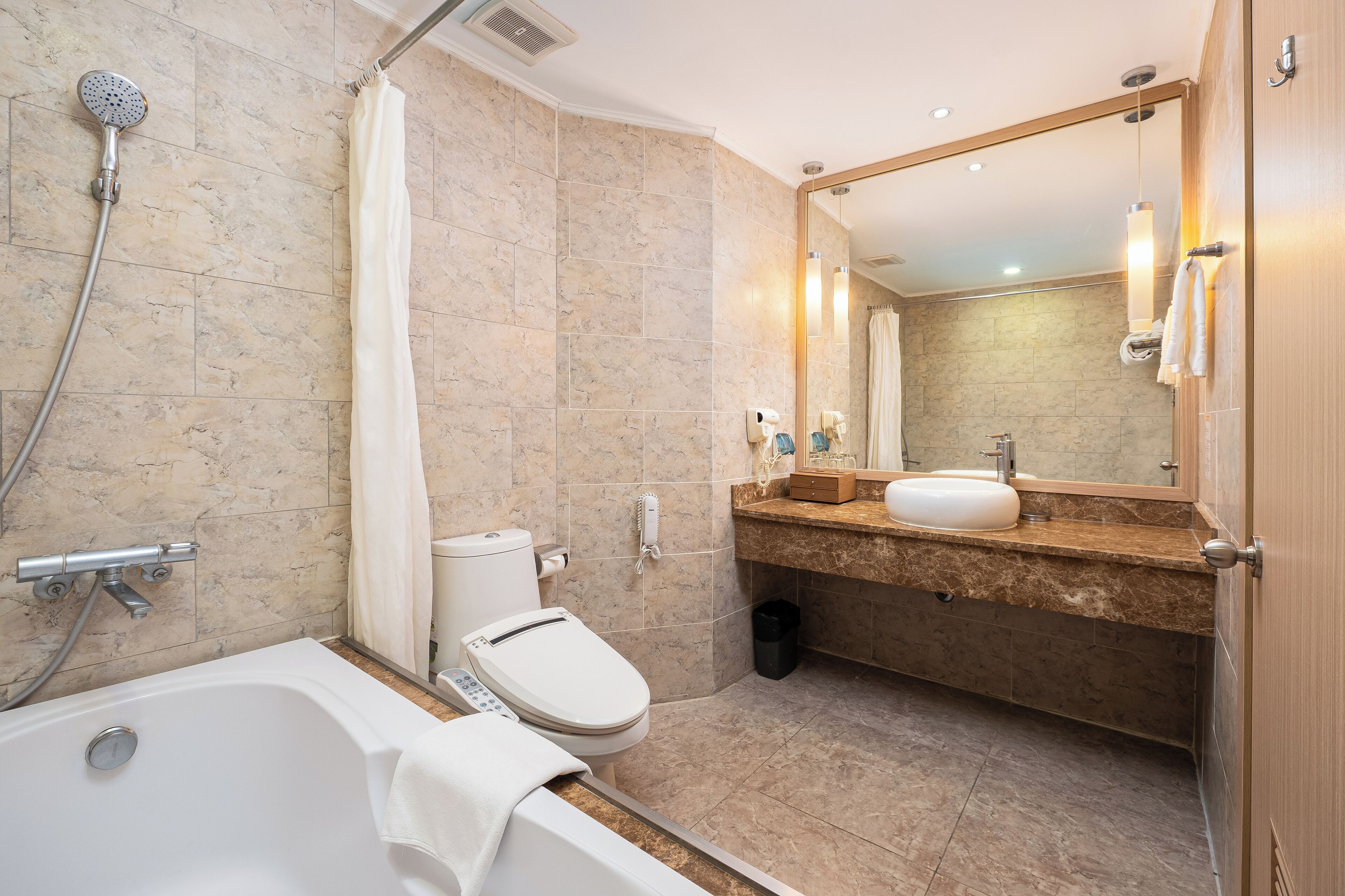 Ein modernes Badezimmer mit Badewanne, Toilette und Waschbecken.