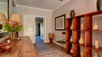 Un mostrador de recepción de madera con un florero, un espejo y un cuadro en la pared.