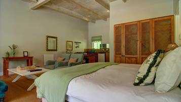A bedroom with a large bed, a desk, a chair, and a wardrobe.