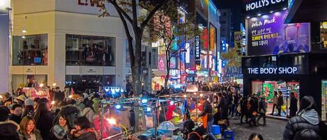 A busy street scene with various shops and a crowd of people.