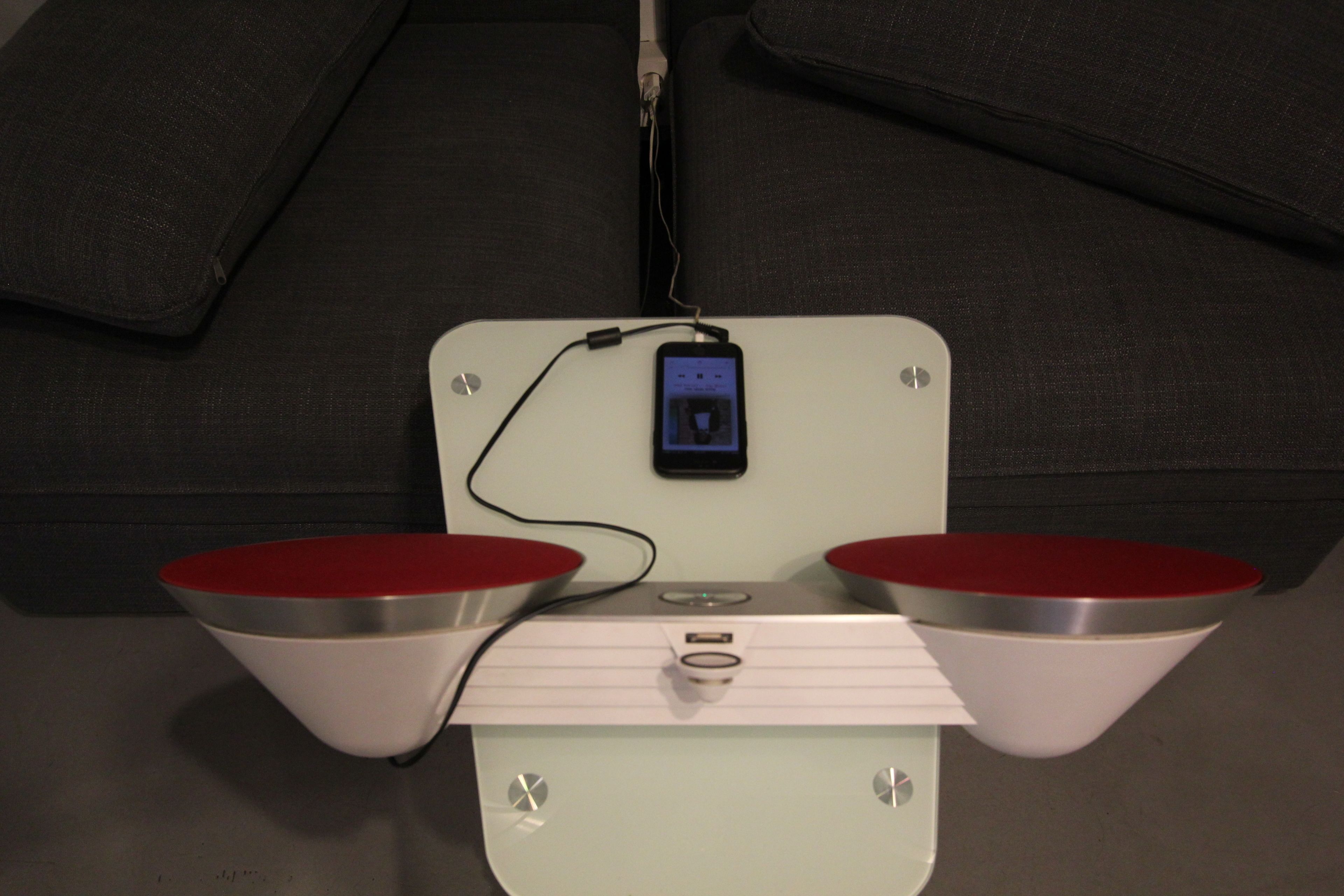 A white table with two red bowls and a black device on top.