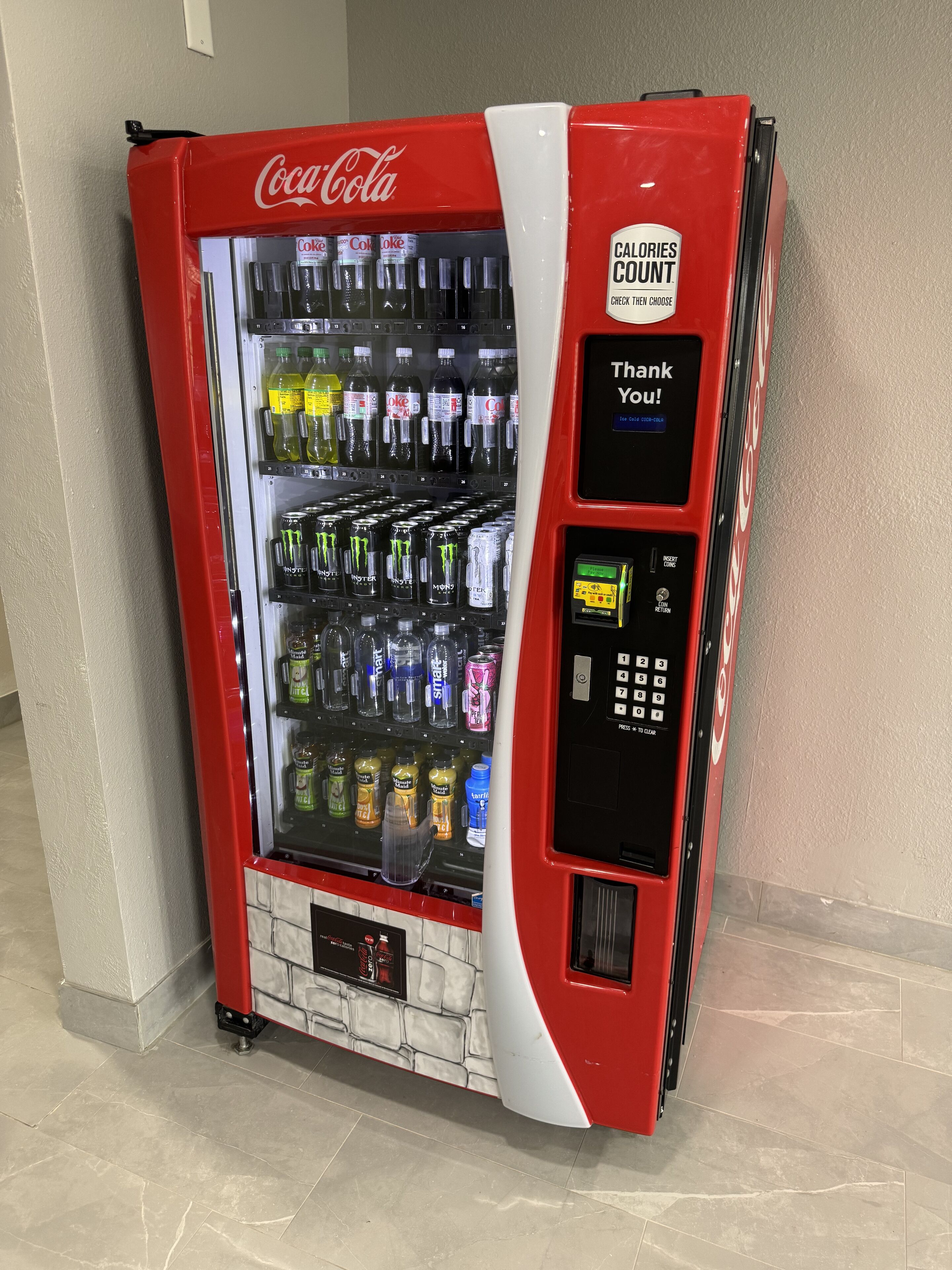 Distributore automatico di Coca-Cola con indicatore delle calorie e messaggio di ringraziamento.