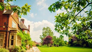 A traditional brick house with a gravel driveway leading to a white outdoor seating area. - Cantley House Hotel (Wokingham)