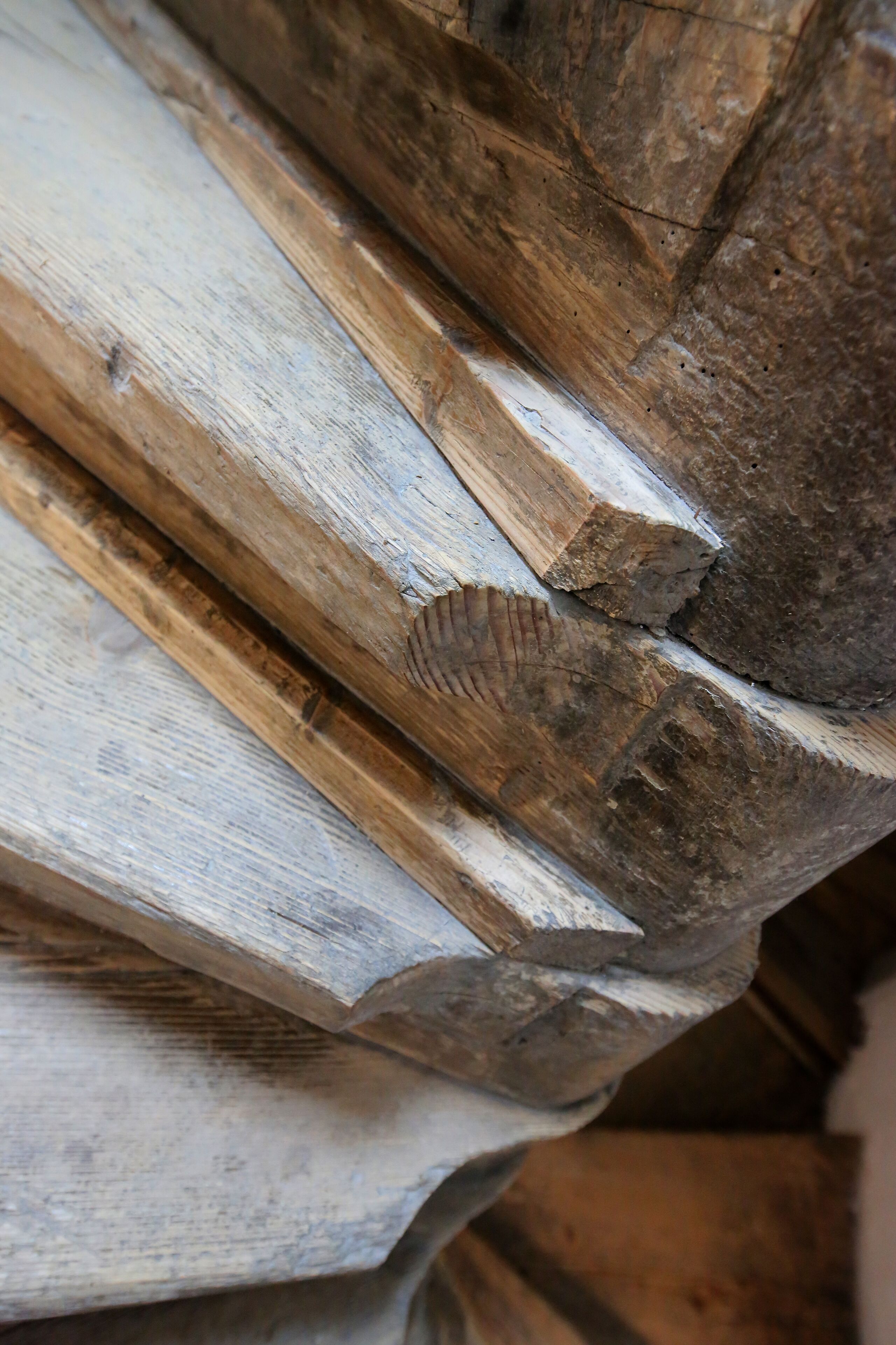 Un gros plan d’une structure en bois ornée d’un motif sculpté en forme de feuilles.
