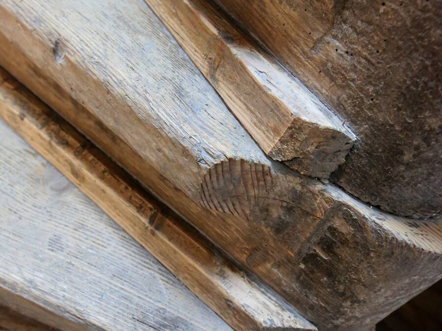 Un gros plan d’une structure en bois ornée d’un motif sculpté en forme de feuilles.