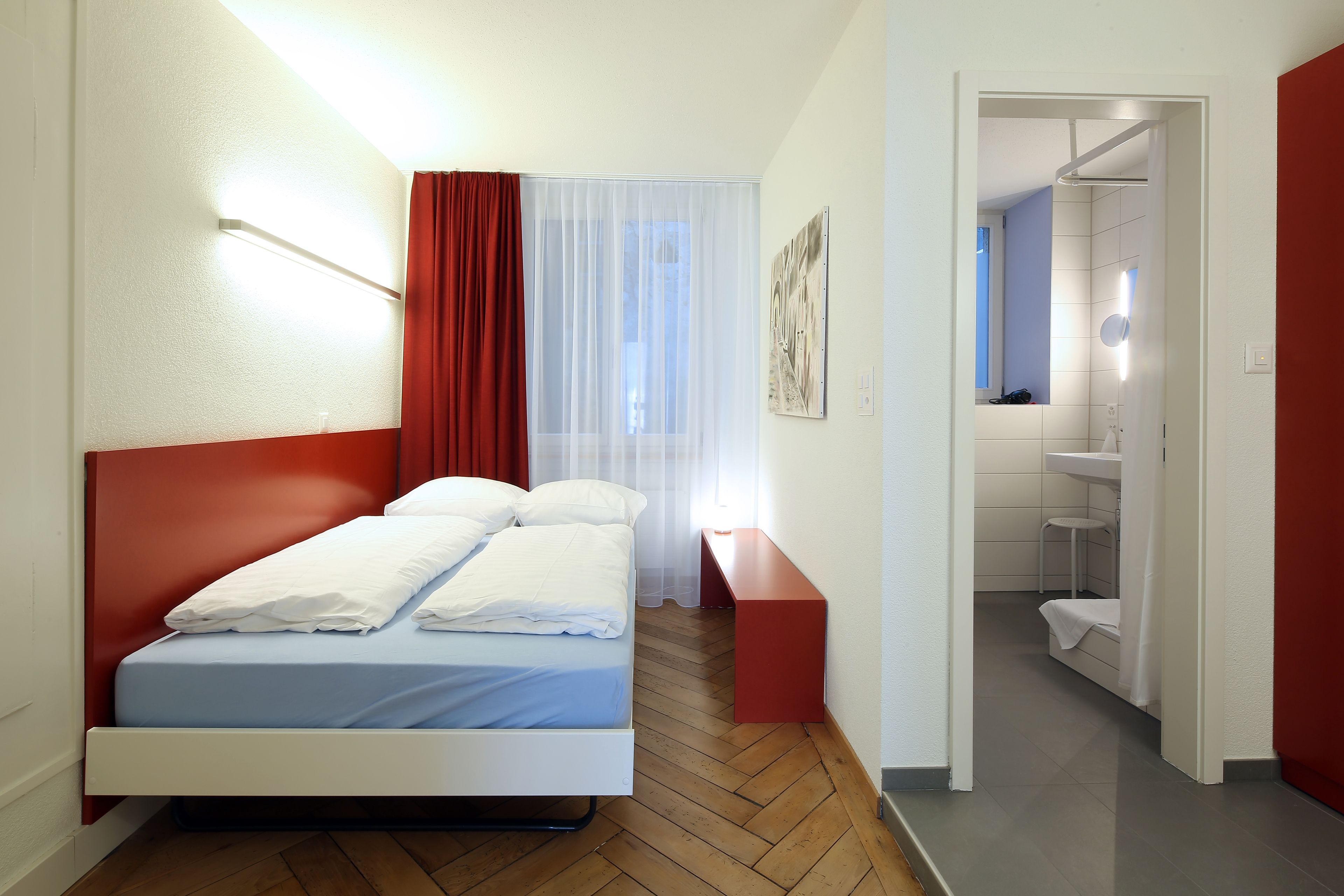 Une chambre à coucher moderne avec un lit, une table de chevet et une vue sur la salle de bain.