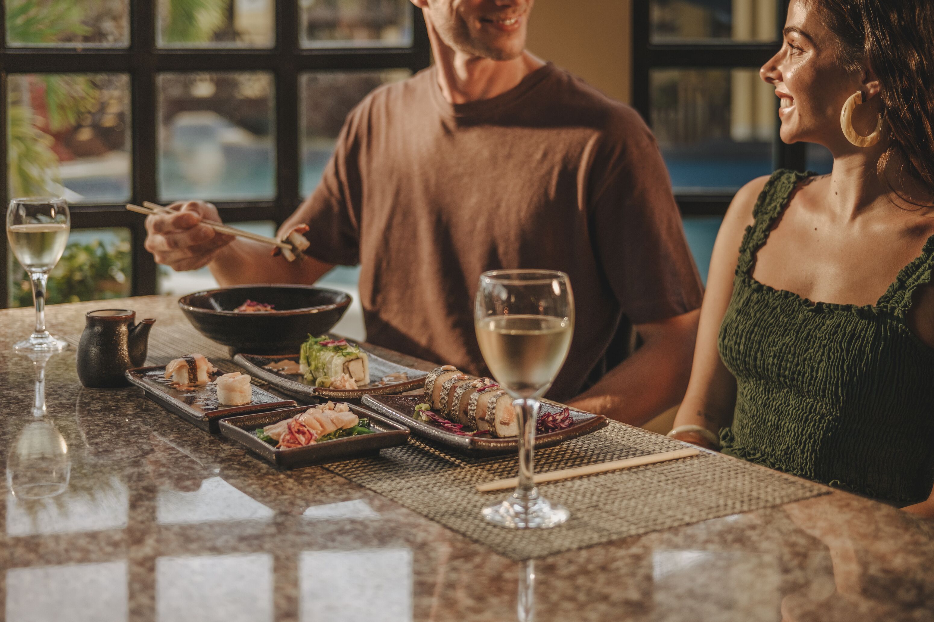 Una mesa de comedor con diferentes platos y copas de vino, evocando un ambiente de restaurante.
