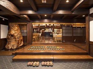 A shoe display with various styles and colors, wooden flooring, and a large sculpture. - Ryokan Asunaro (Takayama)