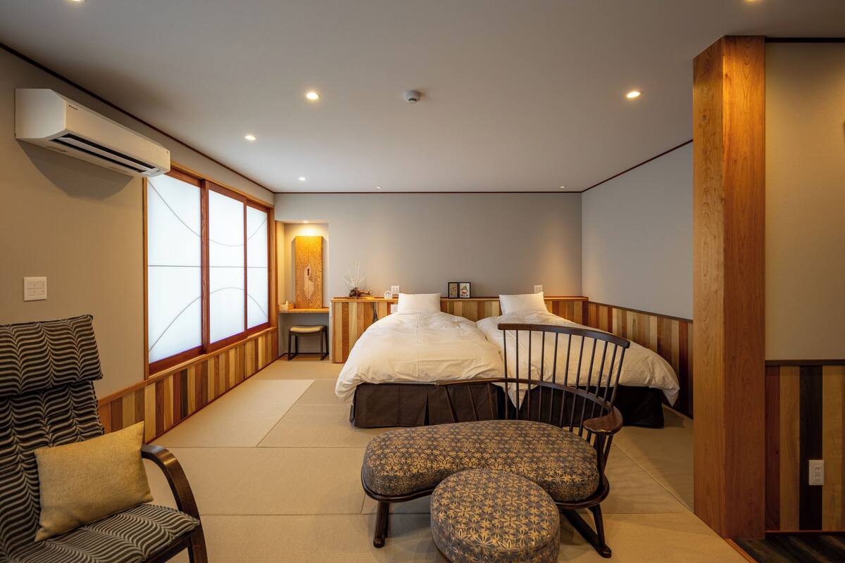 Une chambre d’hôtel avec un grand lit, une chaise, une petite table et un canapé.